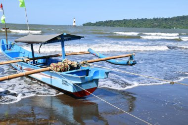 Yerel balıkçı tekneleri, Hindistan Okyanusu 'na bakan Orta Java Endonezya' daki Cilacap 'ın kumlu güney kıyı şeridi boyunca düzgünce dizilmiştir.