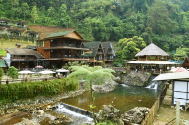 Purwokerto, Endonezya - 20 Haziran 2025: Purwokerto, Purwokerto 'da nehir, şelale ve ormanla çevrili estetik ahşap tasarımlı restoran manzarası.