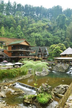 Purwokerto, Endonezya - 20 Haziran 2025: Purwokerto, Purwokerto 'da nehir, şelale ve ormanla çevrili estetik ahşap tasarımlı restoran manzarası.