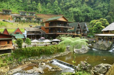Purwokerto, Endonezya - 20 Haziran 2025: Purwokerto, Purwokerto 'da nehir, şelale ve ormanla çevrili estetik ahşap tasarımlı restoran manzarası.