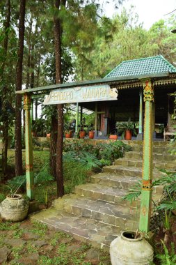 Kuningan, Endonezya - 5 Temmuz 2025: 'Pendopo Wanara' manzarası, Endonezya 'nın Kuningan kentindeki yemyeşil bir orman parkında yer alan yeşil katmanlı geleneksel bir Java ahşap pavyonu.