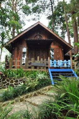 Endonezya, Batı Java, Kuningan 'da yemyeşil tropik bahçelerle çevrili mavi merdivenleri ve çitleri olan büyüleyici bir ahşap kulübe..