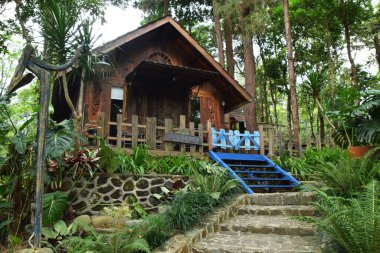 Endonezya, Batı Java, Kuningan 'da yemyeşil tropik bahçelerle çevrili mavi merdivenleri ve çitleri olan büyüleyici bir ahşap kulübe..