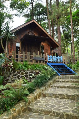 Endonezya, Batı Java, Kuningan 'da yemyeşil tropik bahçelerle çevrili mavi merdivenleri ve çitleri olan büyüleyici bir ahşap kulübe..