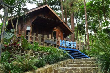 Endonezya, Batı Java, Kuningan 'da yemyeşil tropik bahçelerle çevrili mavi merdivenleri ve çitleri olan büyüleyici bir ahşap kulübe..