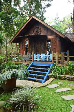 Endonezya, Batı Java, Kuningan 'da yemyeşil tropik bahçelerle çevrili mavi merdivenleri ve çitleri olan büyüleyici bir ahşap kulübe..