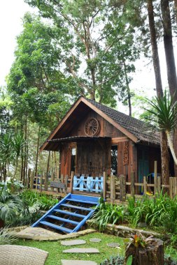 Endonezya, Batı Java, Kuningan 'da yemyeşil tropik bahçelerle çevrili mavi merdivenleri ve çitleri olan büyüleyici bir ahşap kulübe..