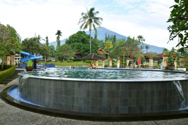 Kuningan, Endonezya - Temmuz 06, 2025: Yeşillik yeşil bahçeler ve arkası görkemli Ciremai Dağı, Kuningan, Endonezya ile çevrili güzel bir tatil köyü yüzme havuzu.