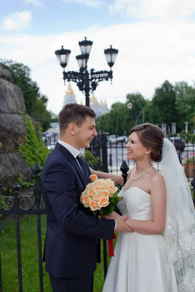 De lyckliga nygifta på en promenad genom staden — Stockfoto