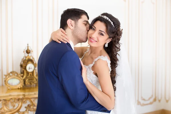 O noivo gentilmente abraça e beija a noiva — Fotografia de Stock
