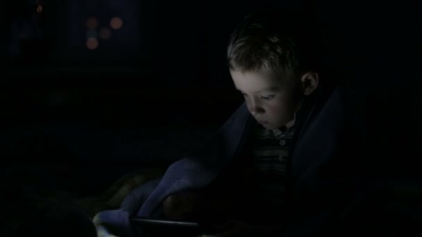 O menino com o tablet embaixo do cobertor 3 — Vídeo de Stock