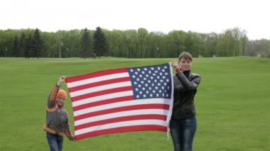 Anne ve oğlu bir bayrak tutan