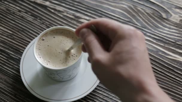 En kopp cappuccino med skum är på bordet — Stockvideo