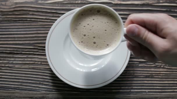 Una taza de capuchino con espuma está sobre la mesa — Vídeos de Stock