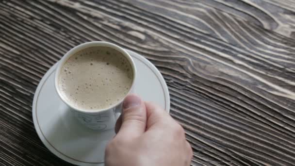 Uma xícara de cappuccino com espuma está sobre a mesa — Vídeo de Stock