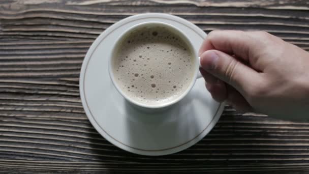 Una taza de capuchino con espuma está sobre la mesa — Vídeos de Stock