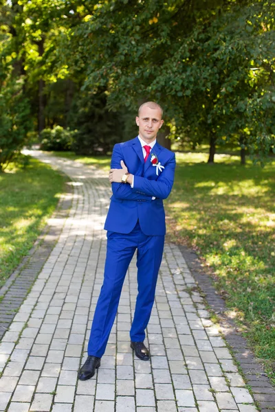 Novio en un traje azul de pie en el callejón — Foto de Stock