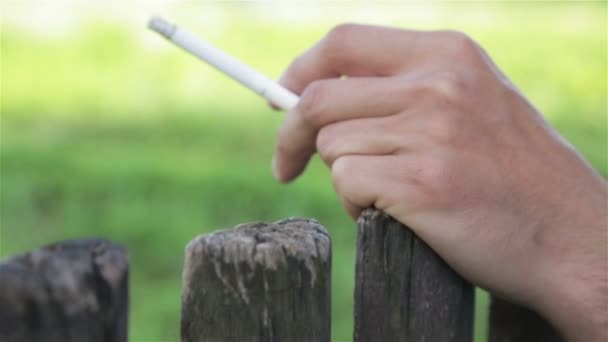 Сжигая сигарету в руке на человека — стоковое видео