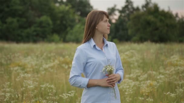 La chica en el prado con flores silvestres — Vídeos de Stock