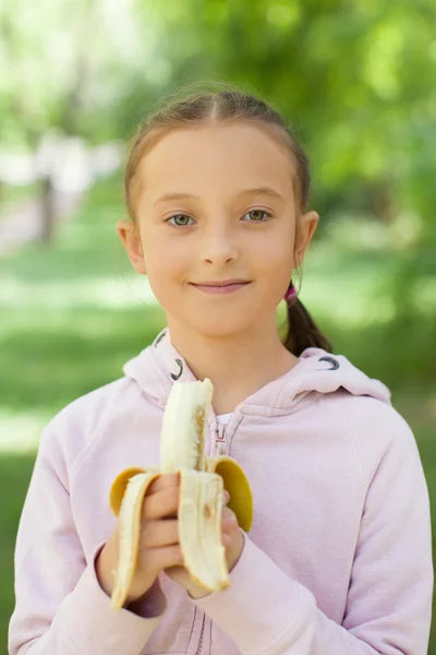 Girl holds banana — Stock Photo, Image