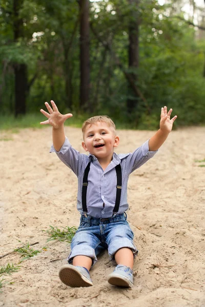 Pojken sitter på sanden — Stockfoto