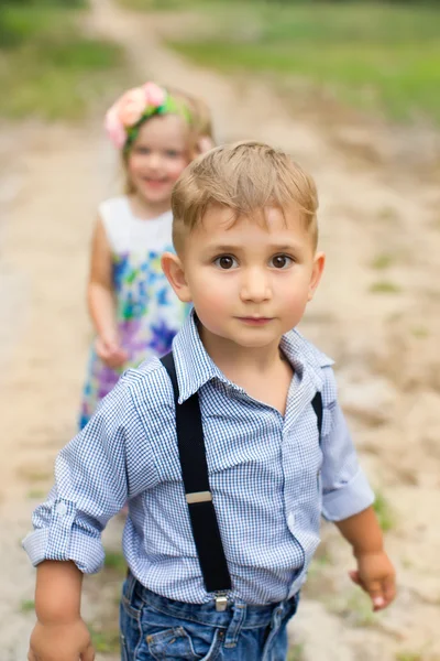 Pojke och flicka som leker i skogen — Stockfoto