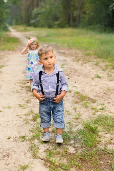 Pojke och flicka som leker i skogen — Stockfoto