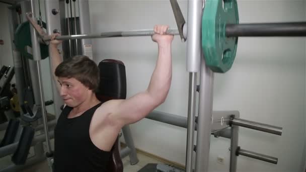 Mannen höjer ribban i gymmet — Stockvideo