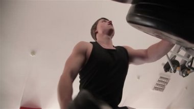 Spor salonunda bir halter kaldırma kas adam kurar