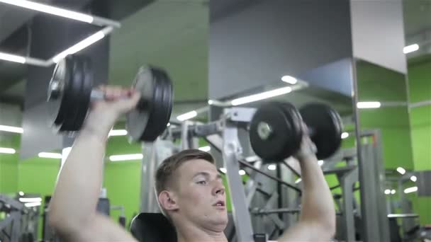 L'homme lève la barre dans la salle de gym — Video