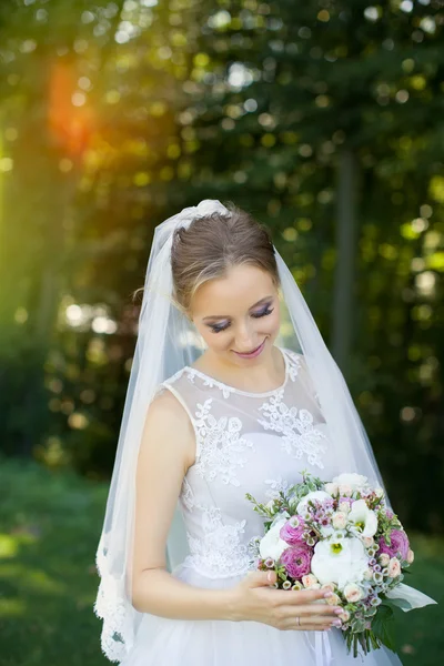 Indah buket pengantin di tangan pengantin muda mengenakan gaun pengantin putih . — Stok Foto