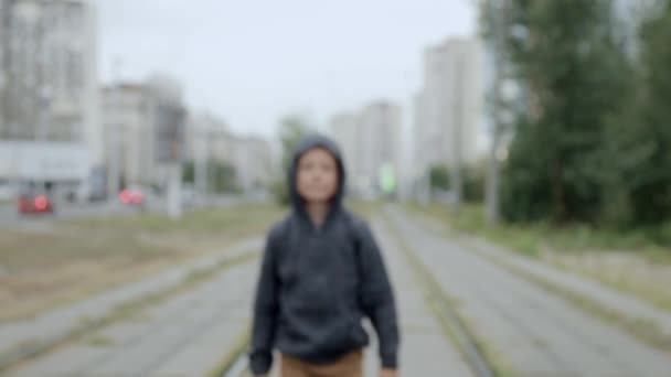 Хлопчик у чорному капюшоні на вулиці — стокове відео
