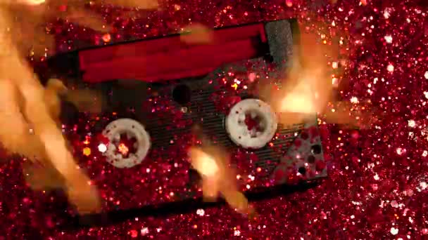赤の輝きの背景に黒のビデオカセット — ストック動画