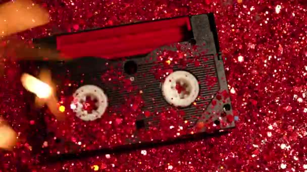 Чорна відеокасета на фоні червоного блиску — стокове відео