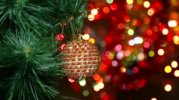 Juguete de Navidad en un árbol de Navidad contra una guirnalda en el desenfoque — Vídeos de Stock