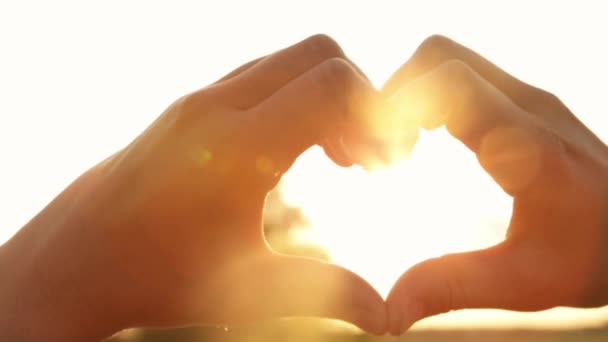Silhouette des mains en forme de cœur avec rayons du soleil couchant — Video