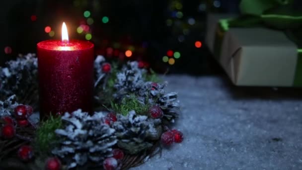 Una vela encendida en la noche de Navidad sobre el fondo de la nieve artificial — Vídeo de stock