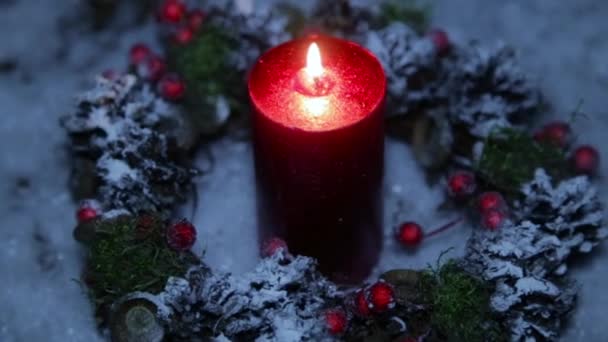 Una vela encendida en la noche de Navidad sobre el fondo de la nieve artificial — Vídeos de Stock