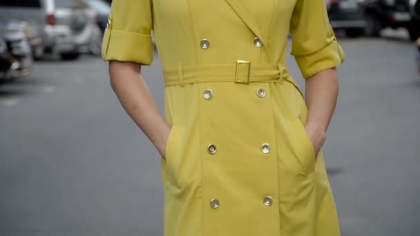 Chica en un vestido amarillo elegante posando en el estacionamiento. Cableado de la cámara de abajo hacia arriba — Vídeos de Stock