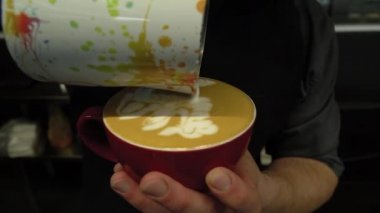 Kahve yapan baristanın eli ya da kahve yapan kapuçino kahvesi Süt döken latte sanatı yapan