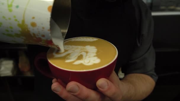 Ręka barista co latte lub cappuccino kawy wylewanie mleka podejmowania sztuki latte — Wideo stockowe