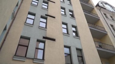 Pencereleri ve balkonları olan yüksek bir bina.