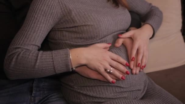 Руки гладят живот беременной девушки — стоковое видео