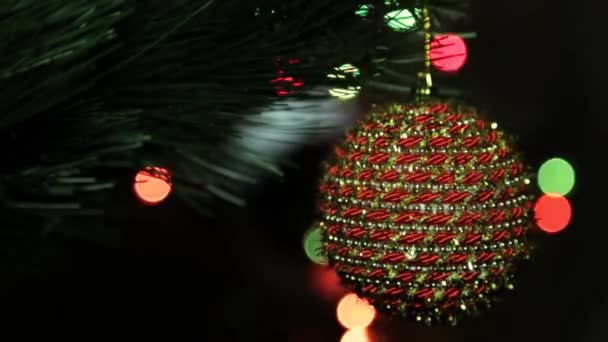 Giocattolo di Natale su un albero di Natale contro una ghirlanda nella macchia — Video Stock