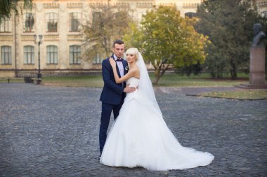 Gelin ve damat bir yürüyüşe kırsal bir yolda kucaklamak