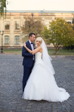 Gelin ve damat bir yürüyüşe kırsal bir yolda kucaklamak