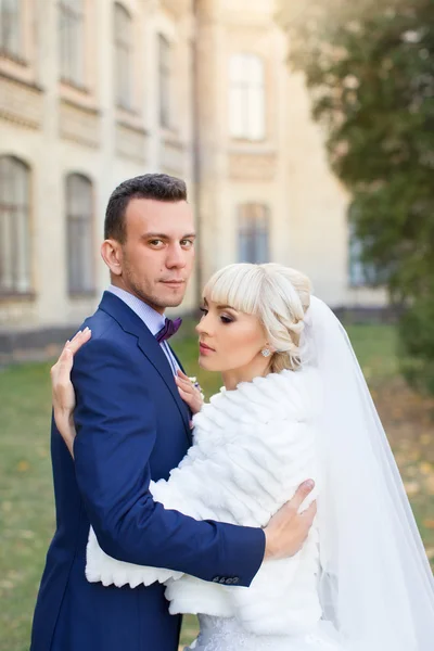 Bruden och brudgummen omfamna på en promenad i landsbygden för en promenad — Stockfoto