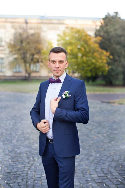 El novio en un traje azul y pajarita posando en la foto —  Fotos de Stock