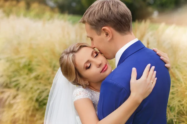 Jonggehuwden op de bruiloft foto schieten in het land — Stockfoto