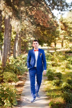 Close-up of the bride in a blue suit with a butterfly